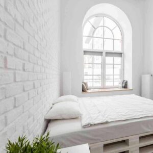 Indretning af soveværelse med flot palleseng og flotte hvide farver.
