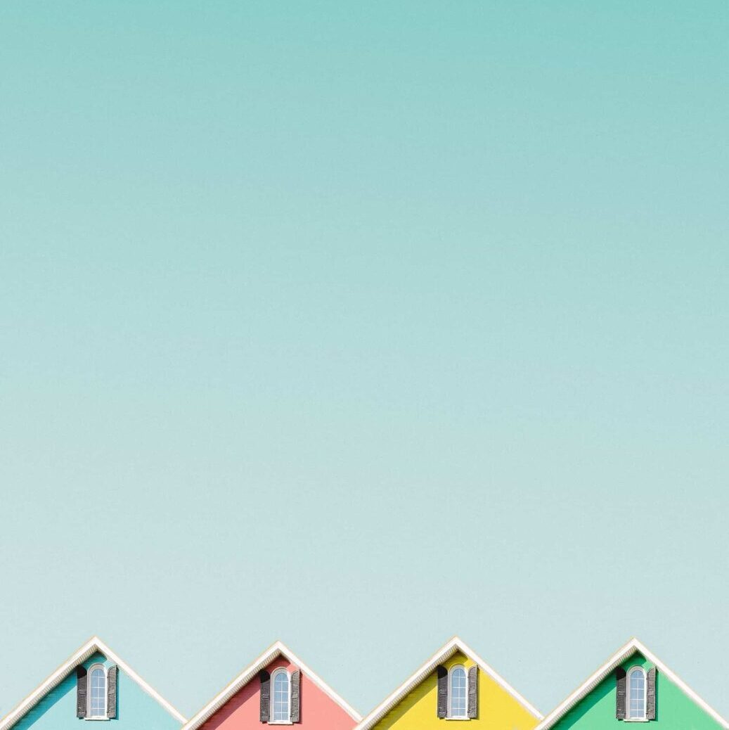 4 hustage i forskellige farver sikker op i bunden af billedet til en turkisblå himmel.
