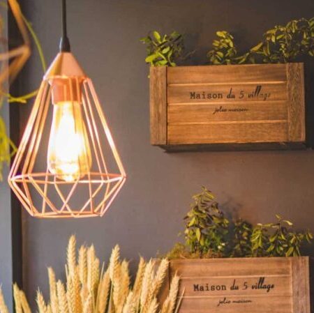 Billede af en væg i entreen der er pyntet med plantekasser og er flotbelyst af en designer lampe