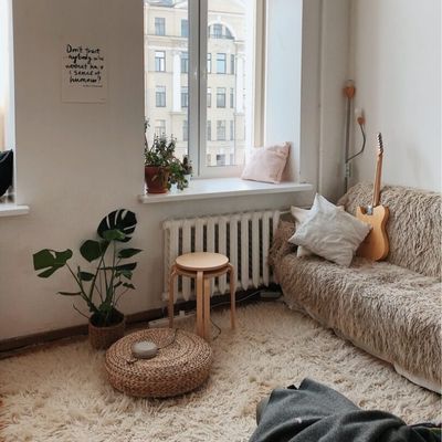 Fin lille firkantet stue med gulvtæpper og sofa i matchende beige farve. 
