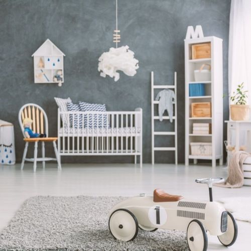 Minimalistisk og stilrent børneværelse med gå vægge, samt hvide og beige møbler og legetøj. 