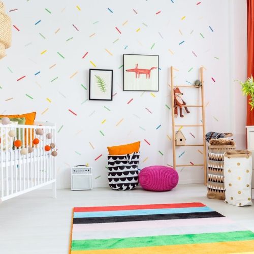 Sødt regnbue børneværelse med friske farver og isdrysmønster på væggen. 
