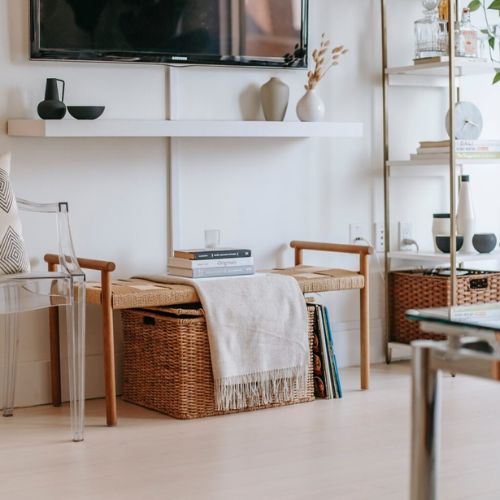 Hyggelig minimalistisk stue med lyse farver, kurve, bøger og hvide hylder. 